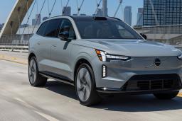 2024 Volvo EX90 in a vapour grey color driving on the road.